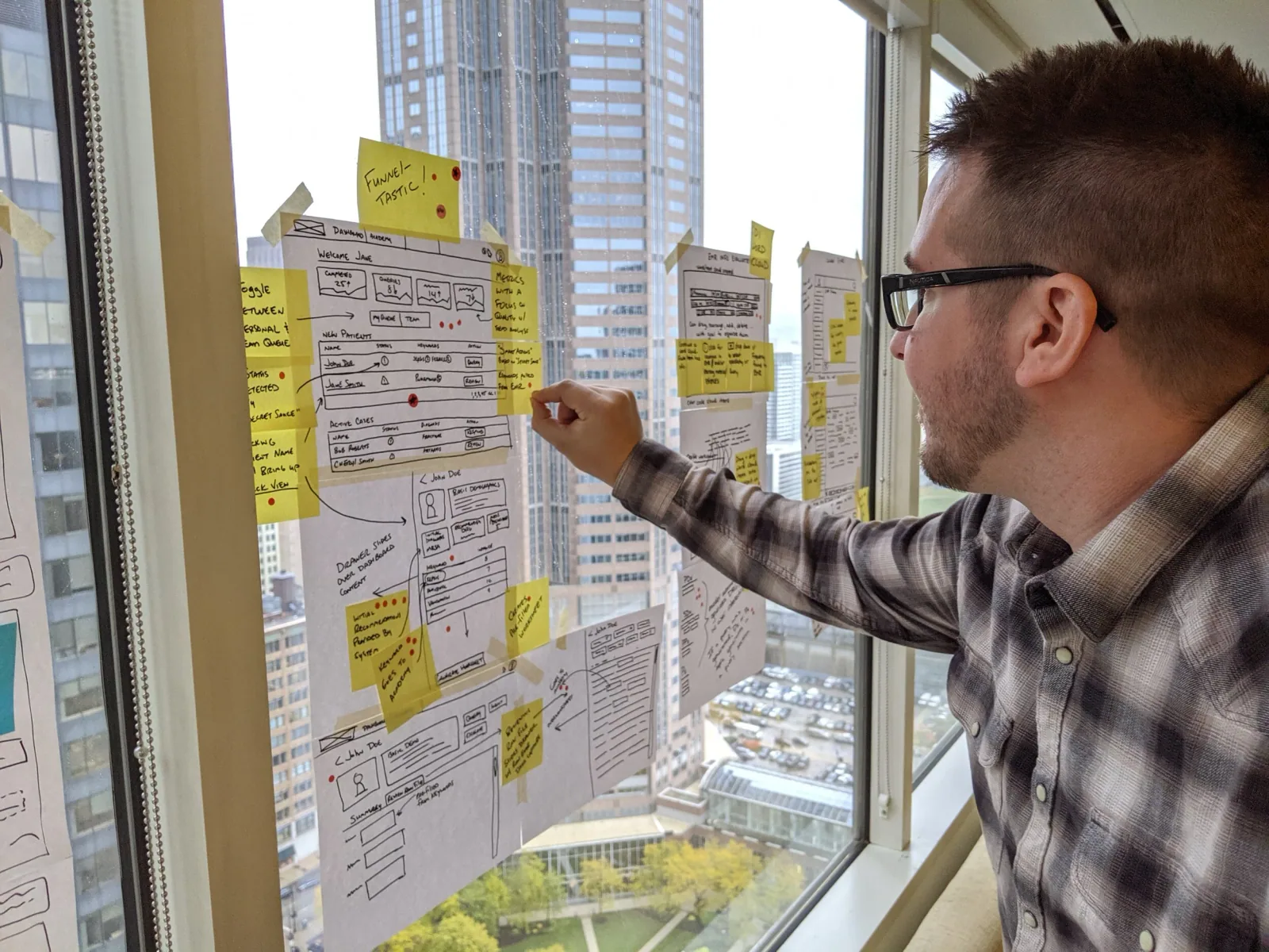 Dan placing sticky notes on a window wall during the design sprint